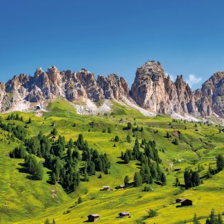 Dolomiten mit grünen Wiesen und Berghütten